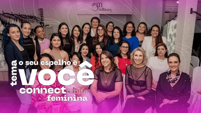 Foto mostra as associadas da Órbita Feminina, algumas sentadas e outras em pé. Com uma legenda: Tema "O seu espelho é você"