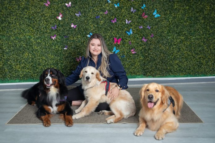 uma mulher sentada em um tapete com cachorros